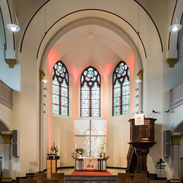 Kirchenaltar mit Buntglasfenstern.