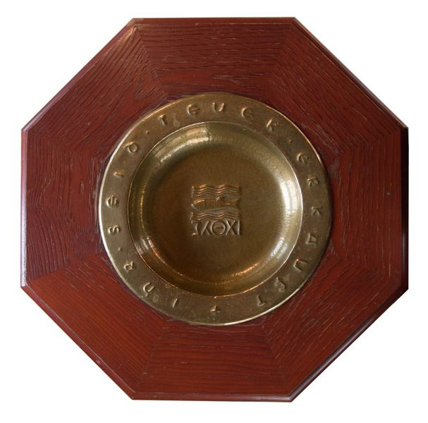 Eine goldene Platte auf einem Holzschild.