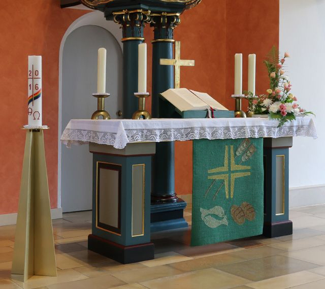 Ein Altar mit Kerzen und Blumen.