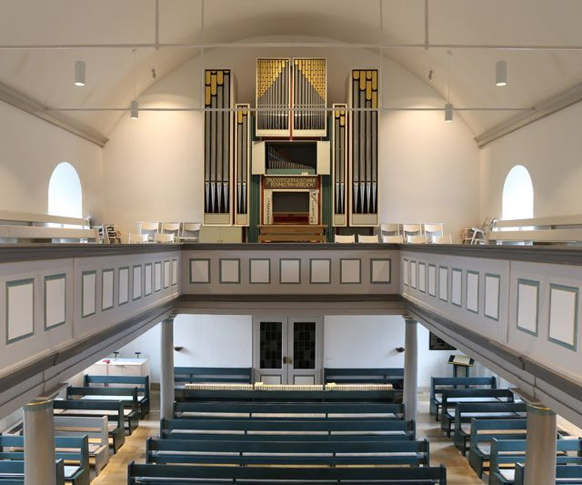 Weitwinkelaufnahme des Kircheninnenraums und der Orgel.